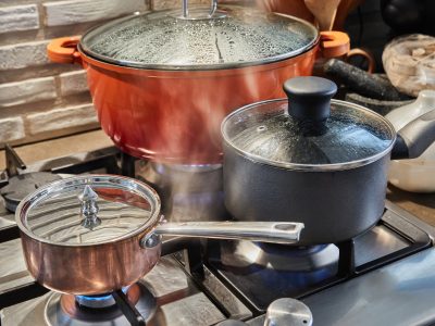 Pots with cooking food in the kitchen on gas stove